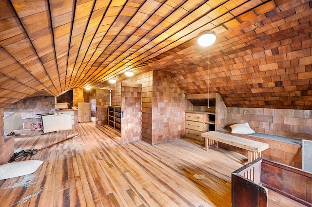 interior space featuring wood walls, light hardwood / wood-style floors, wood ceiling, and lofted ceiling