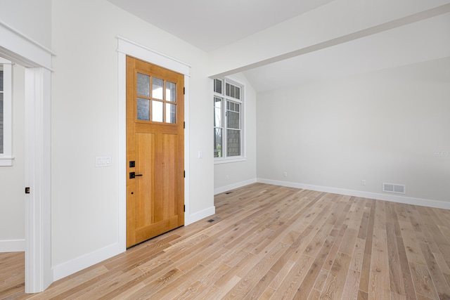 entrance foyer with light hardwood / wood-style floors and vaulted ceiling