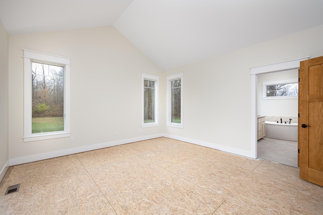 unfurnished bedroom featuring ensuite bath and vaulted ceiling