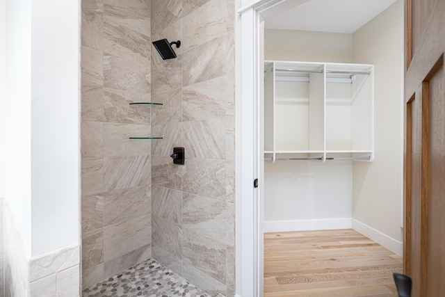 bathroom with wood-type flooring and tiled shower