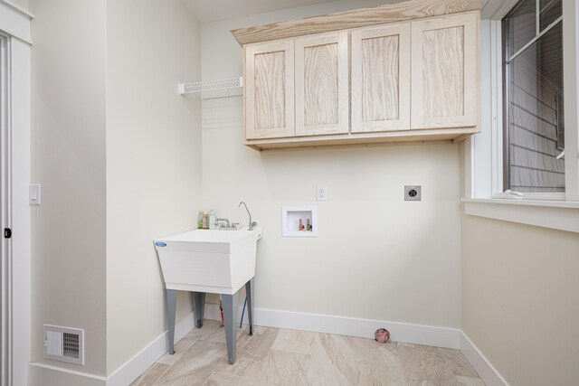 laundry area featuring electric dryer hookup, hookup for a washing machine, and cabinets