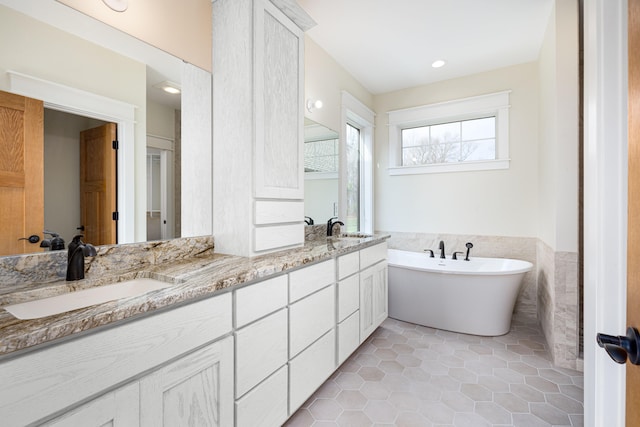 bathroom featuring tile patterned floors, vanity, a bathtub, and tile walls