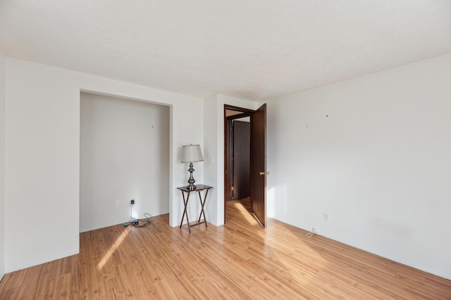 unfurnished room featuring light hardwood / wood-style flooring and a textured ceiling