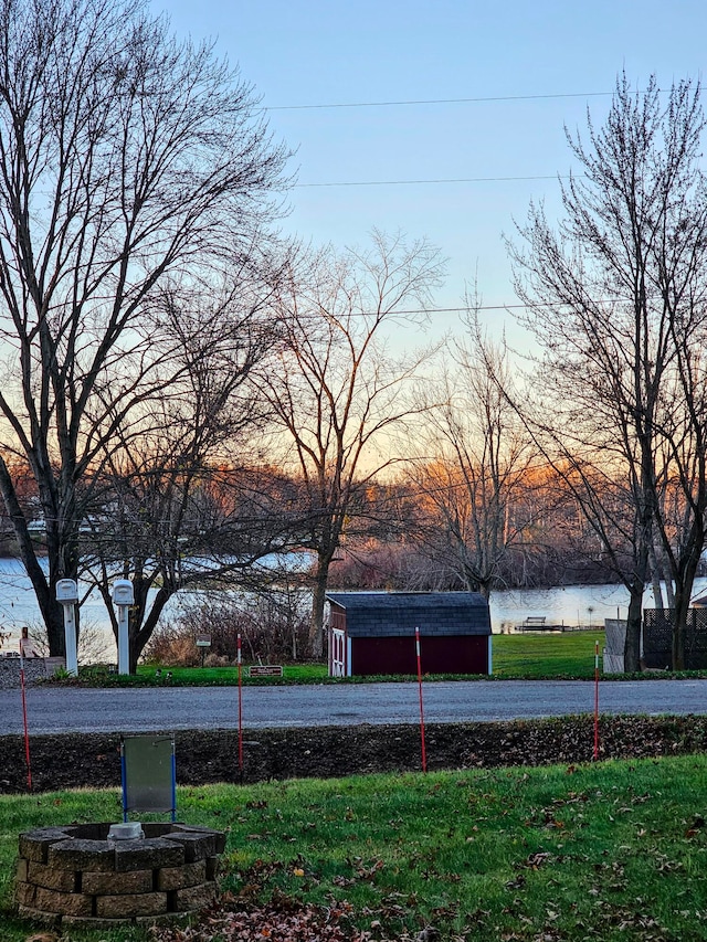 yard at dusk featuring a water view