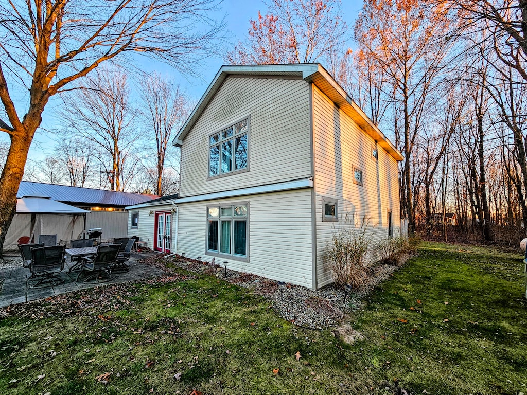 rear view of house featuring a patio area and a yard