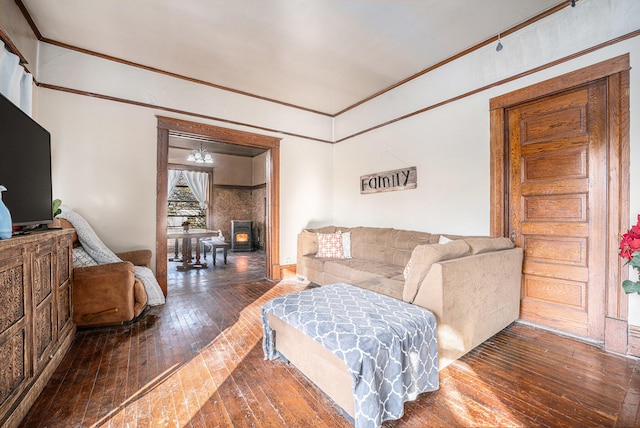 living room featuring wood-type flooring, a wood stove, and crown molding