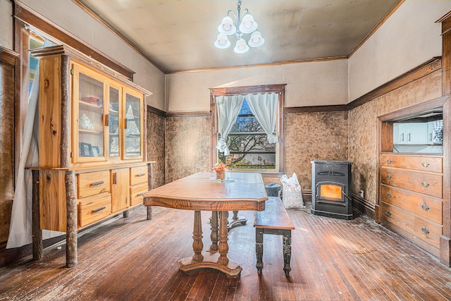 dining space with dark hardwood / wood-style flooring, an inviting chandelier, a wood stove, and ornamental molding