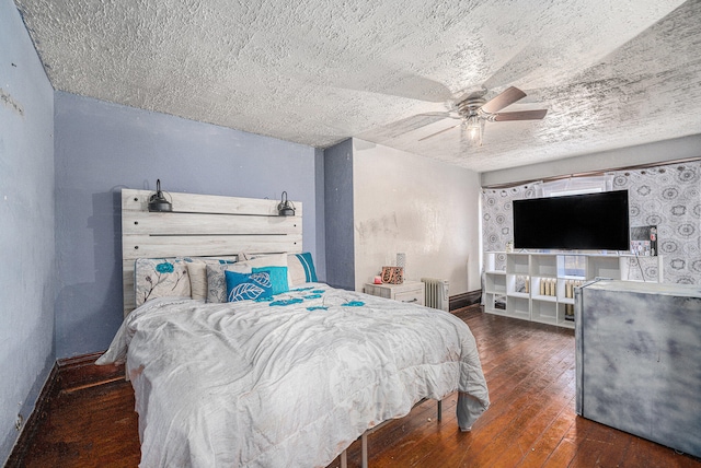 bedroom featuring dark wood-type flooring, radiator heating unit, a textured ceiling, and ceiling fan