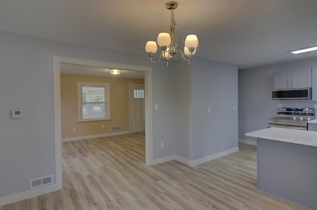 kitchen featuring a chandelier, appliances with stainless steel finishes, light hardwood / wood-style floors, and hanging light fixtures