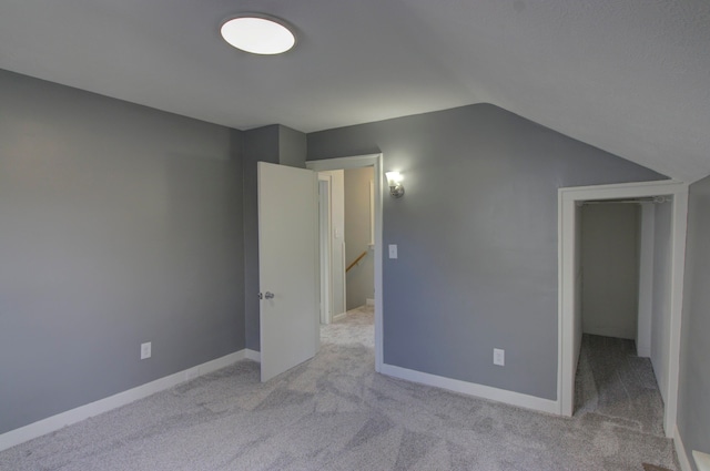 interior space featuring lofted ceiling and light colored carpet