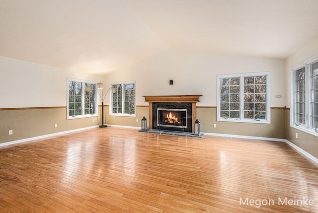 unfurnished living room featuring a fireplace, light hardwood / wood-style floors, and lofted ceiling