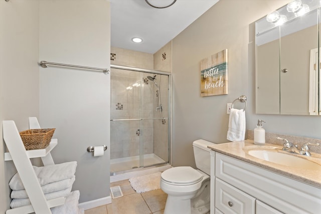 bathroom with toilet, vanity, tile patterned floors, and a shower with door