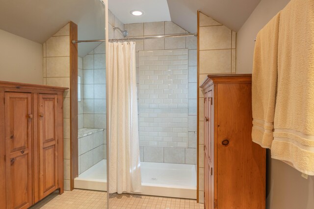 bathroom featuring walk in shower and lofted ceiling