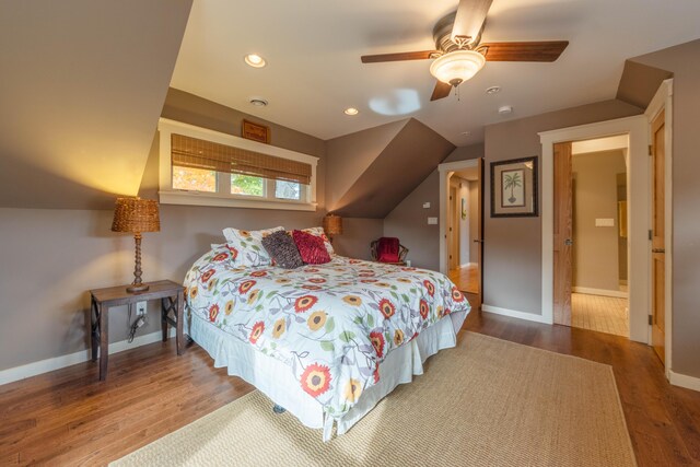 bedroom with ceiling fan, wood-type flooring, and lofted ceiling