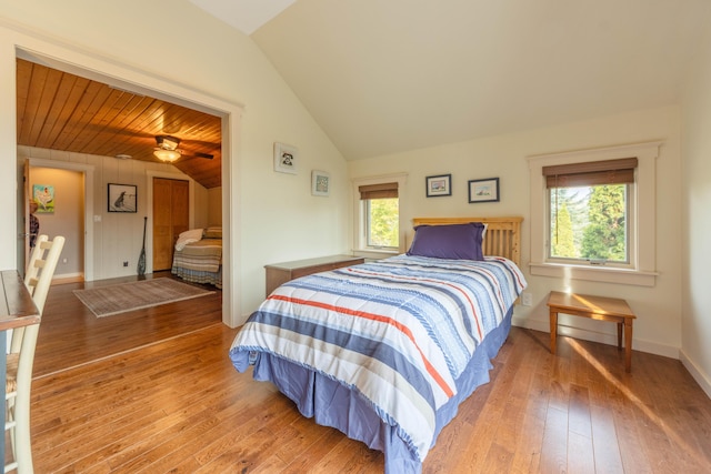 bedroom with vaulted ceiling, hardwood / wood-style floors, wooden ceiling, and multiple windows