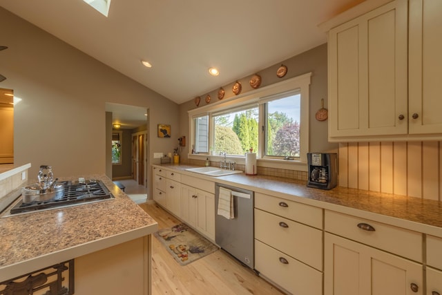 kitchen featuring light hardwood / wood-style flooring, appliances with stainless steel finishes, sink, light stone countertops, and lofted ceiling