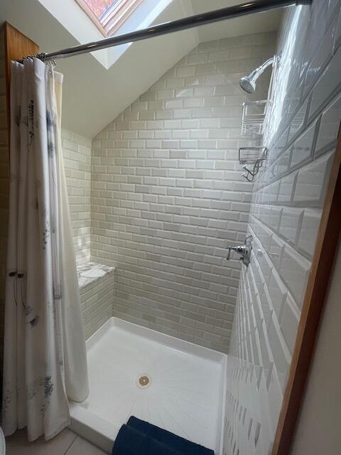 bathroom featuring a shower with curtain and a skylight