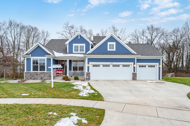 craftsman house with a garage and a front lawn