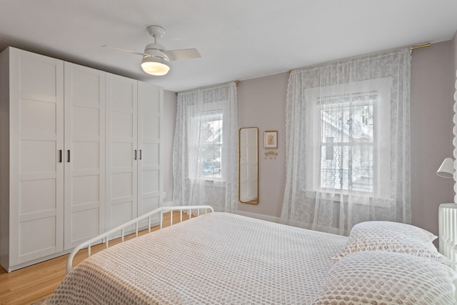 bedroom featuring ceiling fan, light hardwood / wood-style floors, and a closet