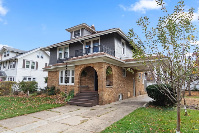 view of front of property featuring a front yard and a balcony