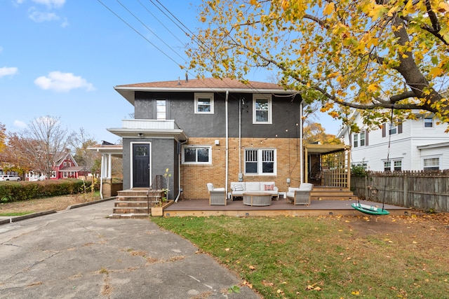 rear view of house featuring an outdoor living space and a yard