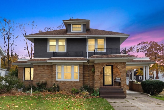 view of front property with a balcony and a yard