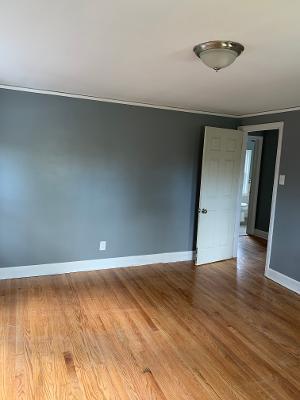 empty room featuring hardwood / wood-style floors and crown molding