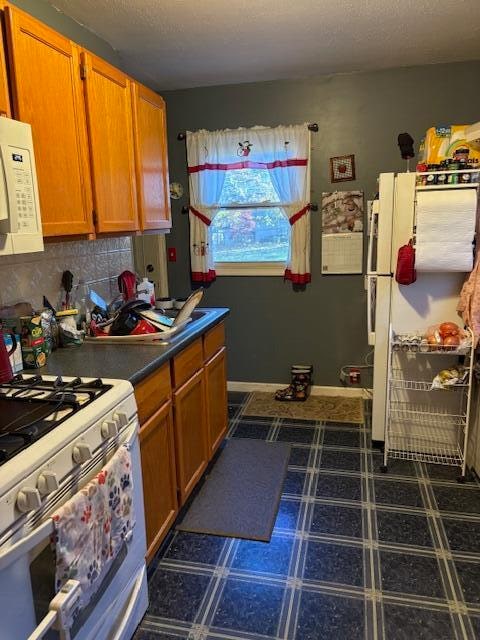 kitchen featuring white appliances and tasteful backsplash