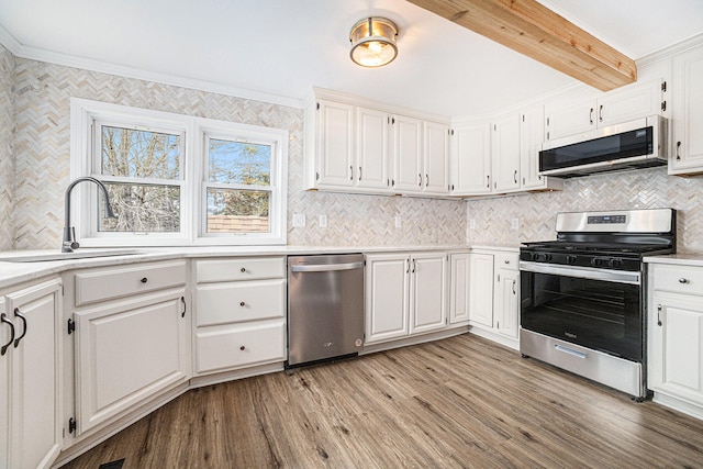 kitchen with white cabinets, stainless steel appliances, and light countertops