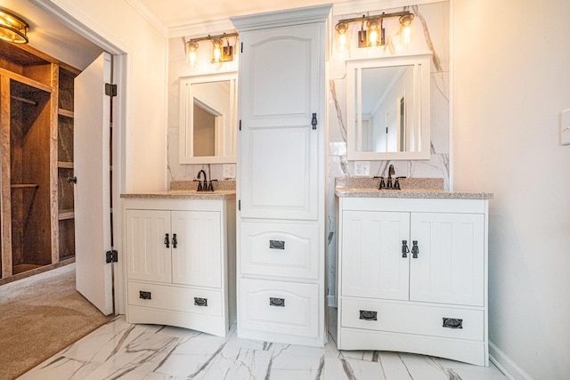 bathroom featuring marble finish floor, baseboards, and two vanities