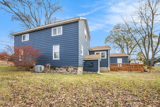 back of property featuring central air condition unit, a lawn, and a deck