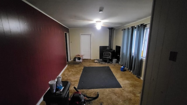 exercise area with a wood stove and crown molding