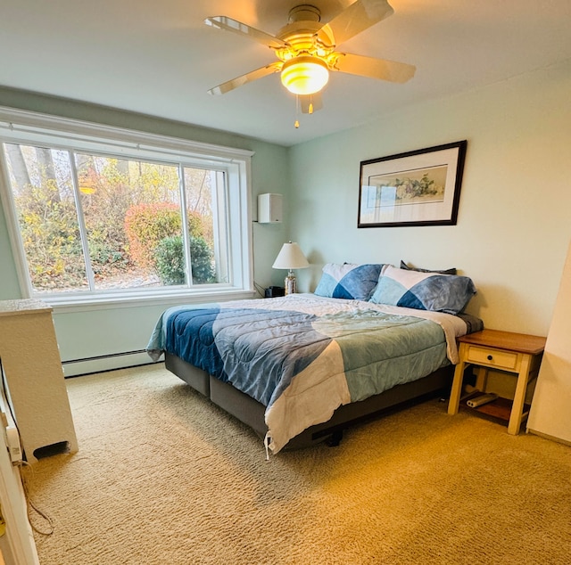 carpeted bedroom featuring baseboard heating and ceiling fan