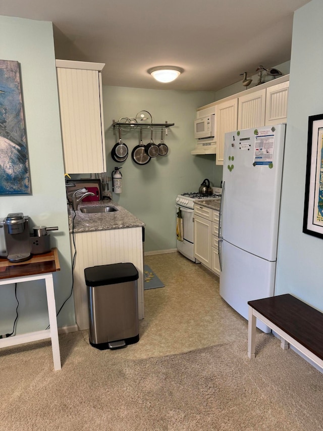 kitchen featuring light colored carpet, white appliances, and sink