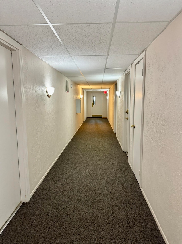 hall featuring a paneled ceiling