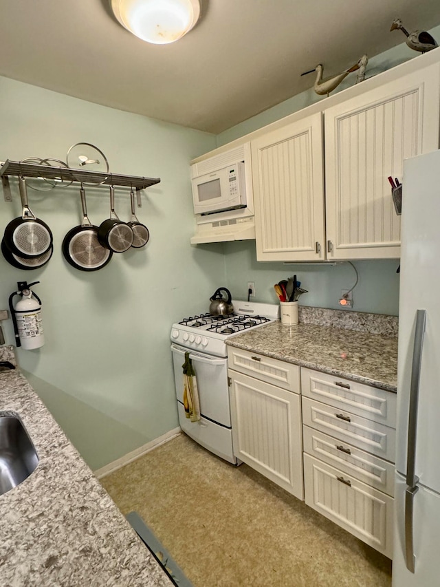 kitchen with light stone countertops, extractor fan, and white appliances