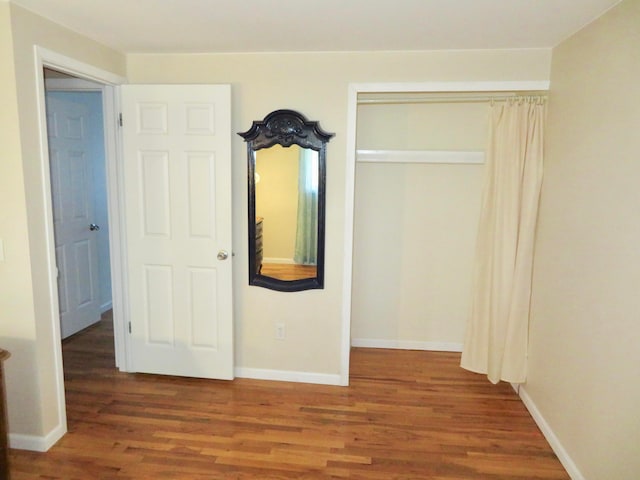 unfurnished bedroom with a closet and hardwood / wood-style floors