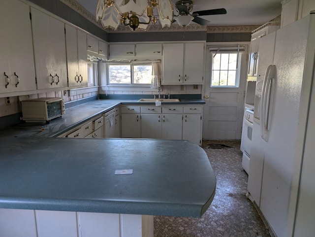 kitchen featuring kitchen peninsula, decorative backsplash, sink, white cabinetry, and white appliances