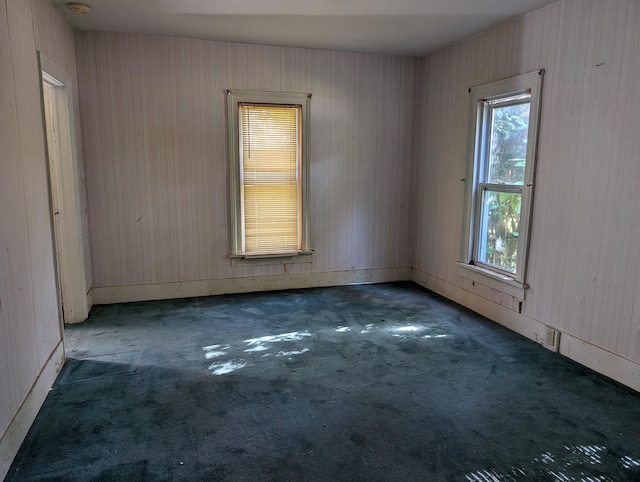 spare room featuring dark colored carpet