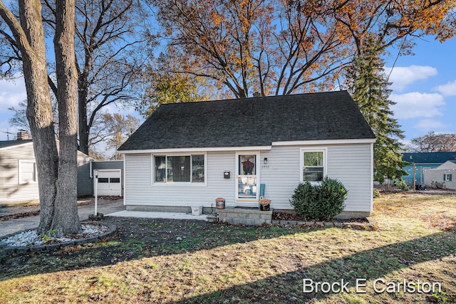 view of front of property featuring an outbuilding, a garage, and a front yard