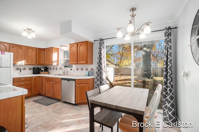 kitchen featuring tasteful backsplash, decorative light fixtures, stainless steel dishwasher, crown molding, and white fridge