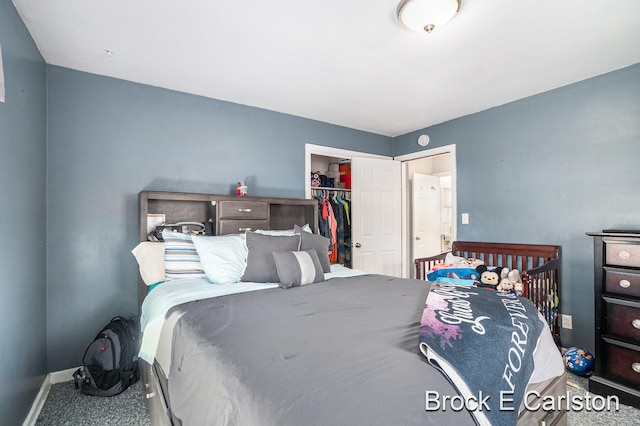 carpeted bedroom with a walk in closet and a closet