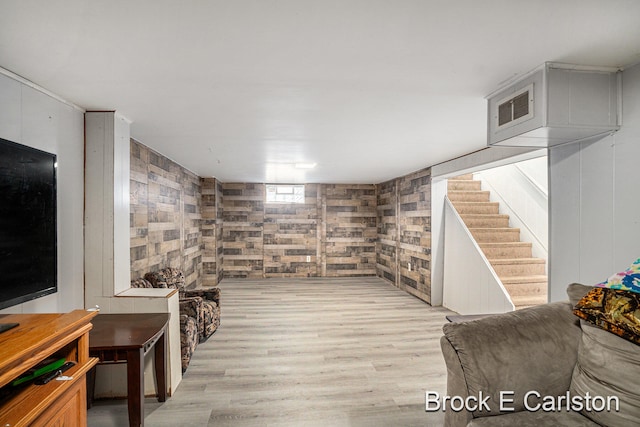 living room with wood walls and light hardwood / wood-style flooring