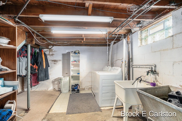 basement featuring washer and clothes dryer and sink