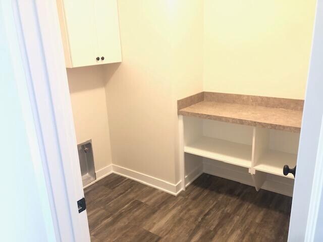 clothes washing area with dark wood-type flooring