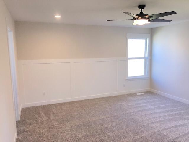 carpeted spare room with ceiling fan