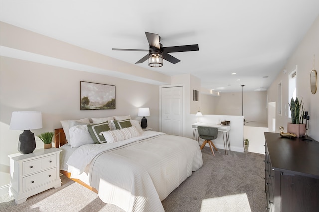 carpeted bedroom featuring ceiling fan and a closet