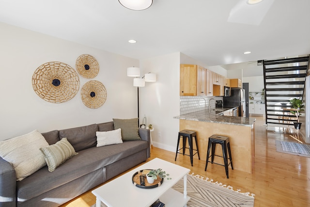 living room with light hardwood / wood-style floors and sink