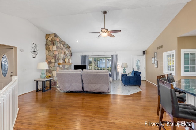 living room with vaulted ceiling, ceiling fan, and wood-type flooring