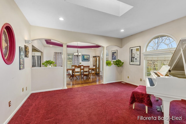 misc room featuring carpet, an inviting chandelier, and ornate columns